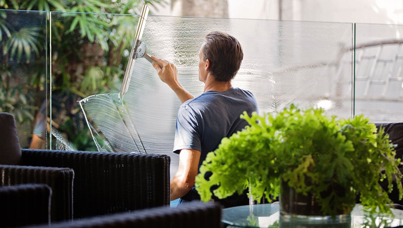Man cleaning window Professional cleaner washing office windows as part of commercial cleaning services in Hertfordshire